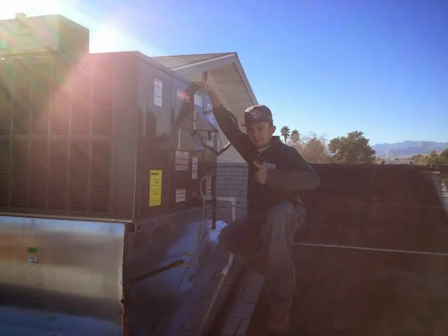 HVAC technician performing Air Duct Cleaning on a rooftop unit in Countryside